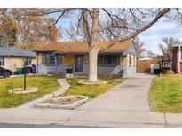 Charming single-story home boasts a manicured front yard, mature trees and a paved driveway at 424 S Leyden St, Denver, CO 80224