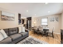 Inviting living room showcases a gray sofa, artwork, and an adjacent dining area at 424 S Leyden St, Denver, CO 80224