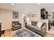 Comfortable living room with gray sofa, armchair, and decorative rug, adjacent to open kitchen at 424 S Leyden St, Denver, CO 80224