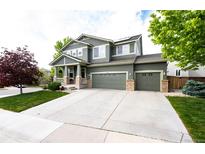 Beautiful two-story home featuring an attached three-car garage and manicured landscaping at 5550 Fox Meadow Ave, Highlands Ranch, CO 80130