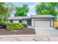 Charming single-story home with a two-car garage, complemented by lush landscaping and a well-maintained yard at 1248 Ilium Dr, Lafayette, CO 80026