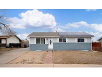 Charming single-story home with a well-maintained lawn and solar panels on the roof at 5411 Chandler Way, Denver, CO 80239