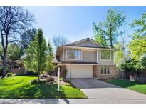 Two-story home with a two-car garage, neutral siding, brick accents, and well-maintained landscaping at 4626 E Links Dr, Centennial, CO 80122