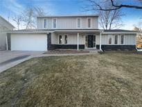 Charming two-story home with a well-manicured lawn and attached two-car garage at 1703 S Moline Ct, Aurora, CO 80012