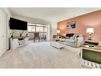 Bright living room featuring neutral carpet, sliding glass doors, and stylish décor at 710 S Alton Way # 5A, Denver, CO 80247