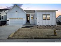 Charming single-Gathering home with modern farmhouse exterior, large windows and an attached two car garage at 11442 Autumn Moon St, Littleton, CO 80125