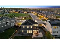 Stunning aerial view of home with solar panels, patio, fenced yard, and neighborhood park at 12264 Olive Way, Thornton, CO 80602