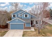 Charming two-story home with a blue exterior, brick accents and well-maintained landscaping at 1898 Wilson Cir, Erie, CO 80516