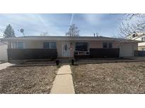 Charming single-story home with a brick facade and well-maintained front yard at 1469 S Reed St, Lakewood, CO 80232
