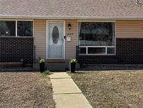 Charming front door with decorative glass and planters along the walkway at 1469 S Reed St, Lakewood, CO 80232