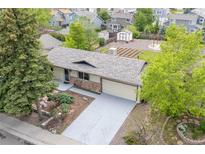 Charming ranch-style home featuring a well-maintained lawn and a large driveway leading to an attached two-car garage at 6147 Dunraven St, Golden, CO 80403