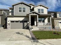 Two-story house with gray siding, attached garage, and landscaped yard at 5581 Wisteria Ave, Firestone, CO 80504