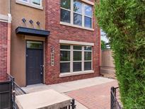 Charming brick townhome featuring a private entrance with stylish black door and inviting curb appeal at 8983 E Nichols Pl, Centennial, CO 80112