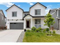 Charming two-story home featuring a well-manicured lawn and a welcoming front porch with inviting seating at 1369 E Witherspoon Dr, Elizabeth, CO 80107