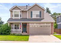 Charming two-story home featuring a well-manicured lawn, brick accents, and an attached two-car garage at 9810 Mulberry Way, Highlands Ranch, CO 80129