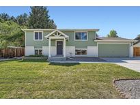 Charming two-story home with a well-manicured lawn, lush landscaping, and attached two car garage at 1183 S Pierson Ct, Denver, CO 80232