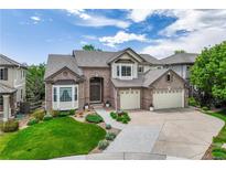 Charming two-story brick home boasts a well-manicured lawn, mature trees, and a spacious three-car garage at 6095 S Oswego St, Greenwood Village, CO 80111