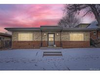 Charming single-story brick home with a cozy entrance and snow-covered front yard at 3420 Tennyson St # 105, Denver, CO 80212