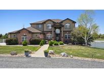 Beautiful two-story home with well-maintained landscaping and a charming brick accent at 14953 Akron Ct, Brighton, CO 80602