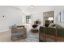 Sunlit living room boasts modern furnishings, fireplace, and sliding glass doors to a balcony at 580 Vance St # A, Lakewood, CO 80226