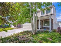 Charming two-story home featuring a stone facade, attached garage, and landscaped front yard with mature trees at 4435 Andes Ct, Denver, CO 80249