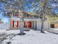 Two-story house with gray siding, red shutters, and a snow-covered front yard at 11427 Brownstone Dr, Parker, CO 80138