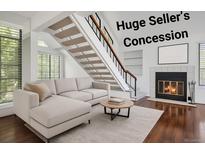 Cozy living room features a fireplace, stairs, and hardwood floors, creating a warm and inviting atmosphere at 4802 E Kentucky Ave # E, Denver, CO 80246