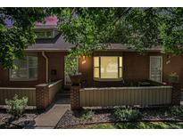 Charming brick townhome featuring a bay window, neat landscaping, and a welcoming front entrance at 3300 W Florida Ave # 51, Denver, CO 80219