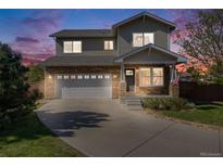 Charming two-story home with stone accents, well-manicured lawn, and inviting curb appeal at dusk at 19294 E Warren Pl, Aurora, CO 80013
