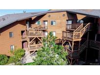 Exterior view of brown building featuring multiple balconies, staircases and mature landscaping at 6110 Habitat Dr # 2, Boulder, CO 80301