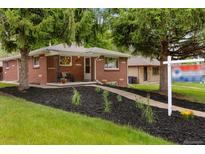Charming brick home with a cozy front porch and mature trees in a well-manicured front yard at 5185 N Meade Street St, Denver, CO 80221