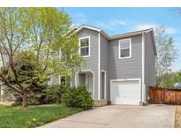 Charming two-story home featuring gray siding, well-kept landscaping, and an attached one car garage at 1365 Waxwing Ave, Brighton, CO 80601
