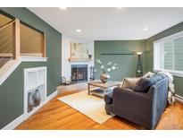 Charming living room featuring hardwood floors, a cozy fireplace, and a view of the modern staircase at 2976 Eagle Way, Boulder, CO 80301