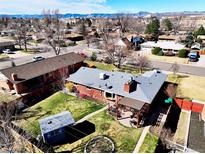 Aerial view of a lovely brick home featuring a pergola-covered patio and a well-maintained backyard with mature trees at 380 S Newland St, Lakewood, CO 80226