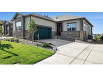 Charming home featuring stone accents, a well-manicured lawn, and a driveway leading to an attached two-car garage at 811 W 128Th Pl, Westminster, CO 80234