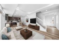 Bright open-concept living room features recessed lighting, a modern staircase and stylish decor, seamlessly connecting to the kitchen at 1170 Sugarloaf Ln, Erie, CO 80516