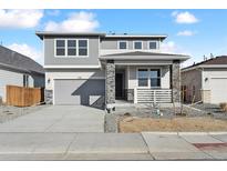 Charming two-story home featuring a stone-accented porch, gray siding, and a well-maintained front yard at 250 Lark Sparrow Way, Bennett, CO 80102