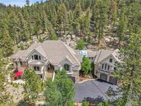 Beautiful exterior view of a house nestled amongst the trees in a mountainous location at 4158 Wild Flower Ct, Evergreen, CO 80439