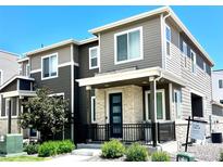 Modern two-story home featuring a stylish facade, stone accents, and a welcoming front porch at 12301 Festival Ln, Thornton, CO 80241