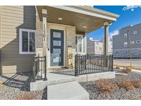 Charming front porch with black railings and a modern front door welcomes you home at 12301 Festival Ln, Thornton, CO 80241
