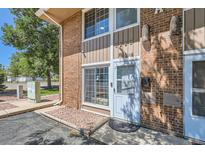 Exterior front entrance of home featuring brick facade, modern lighting, and well-kept walkway at 5225 Balsam St # 1, Arvada, CO 80002