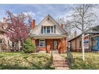 Charming brick home with a peaked roof, well-maintained lawn, and mature landscaping at 130 S Corona St, Denver, CO 80209