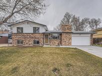 Charming two-story brick home featuring an attached garage and well-maintained front yard at 2893 S Joslin Ct, Denver, CO 80227