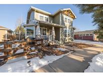 Two-story house with a front porch and a wooden fence, snow on the ground at 16935 Buffalo Valley Path, Monument, CO 80132