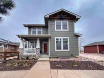 Charming two-story home features a covered porch with stone accents and a well-maintained front yard at 16935 Buffalo Valley Path, Monument, CO 80132