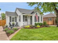 Charming home with a well-manicured front yard, black shutters and chairs, and an American flag at 2212 Ingalls St, Edgewater, CO 80214