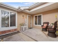 Inviting front porch with wicker chairs and a cozy seating area, perfect for relaxing outdoors at 8112 Gray Ct # 394, Arvada, CO 80003