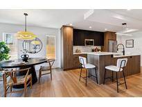 Modern kitchen with stainless steel appliances, an island, and bar seating at 3430 W 25Th Ave, Denver, CO 80211