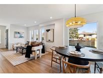 Bright living room with hardwood floors and neutral decor flowing into adjacent dining space at 3430 W 25Th Ave, Denver, CO 80211