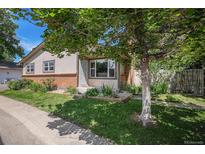 Charming single-Gathering home featuring a landscaped front yard and mature tree, creating a welcoming curb appeal at 64 Nome Way # A, Aurora, CO 80012